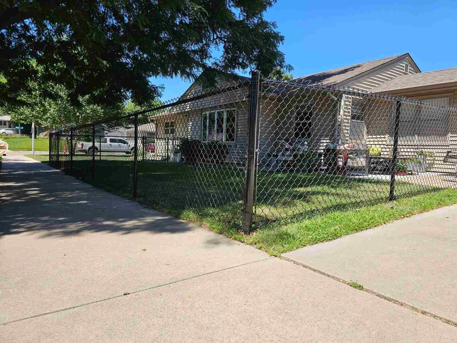 Black chain link fence along a street-side front yard