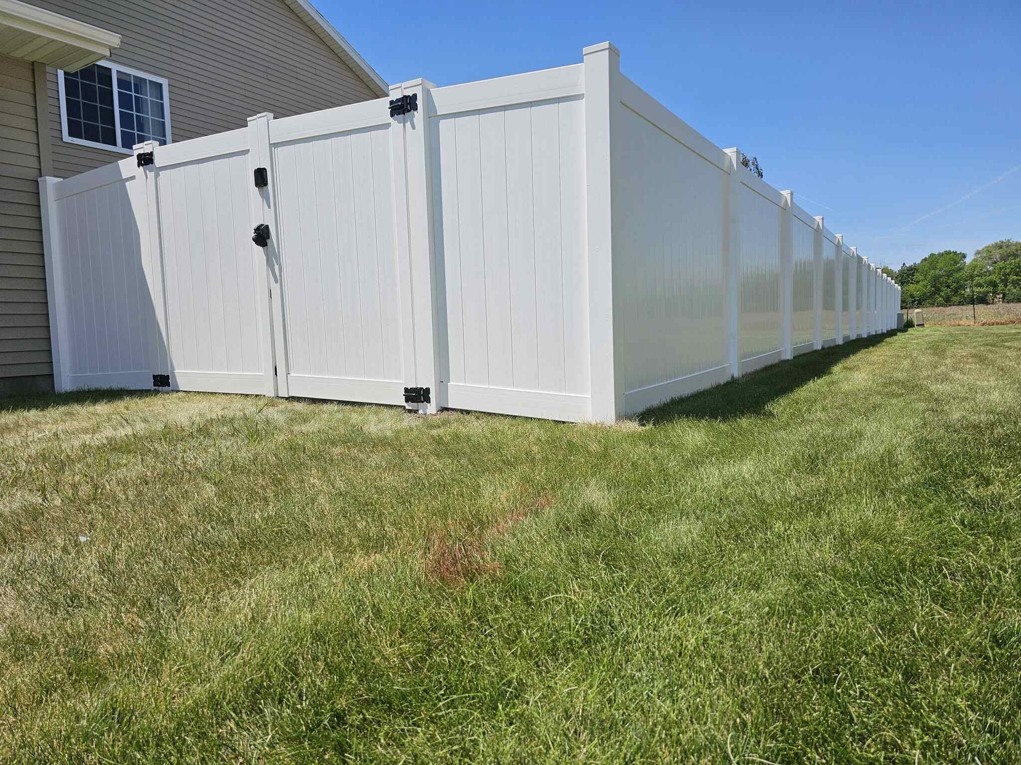 White vinyl privacy fence with a double swing gate