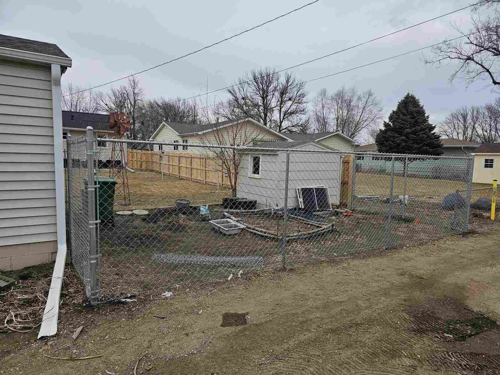 Galvanized chain link and gate along a backyard alley