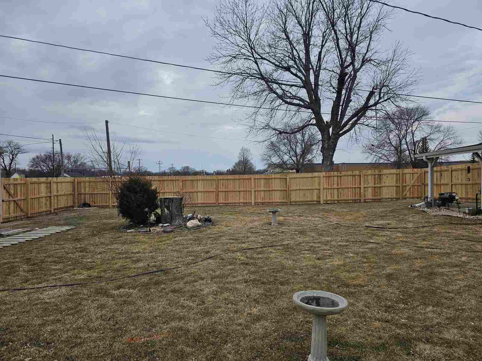 Cedar privacy fence with a birdbath in the yard