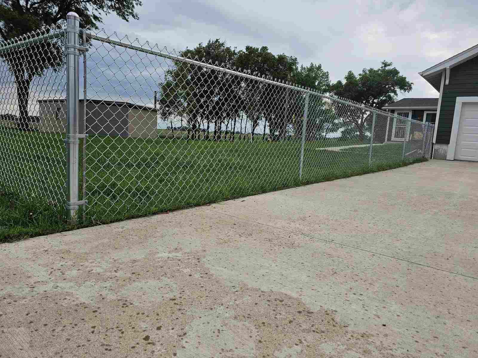 Galvanized chain link fence with a driveway gate