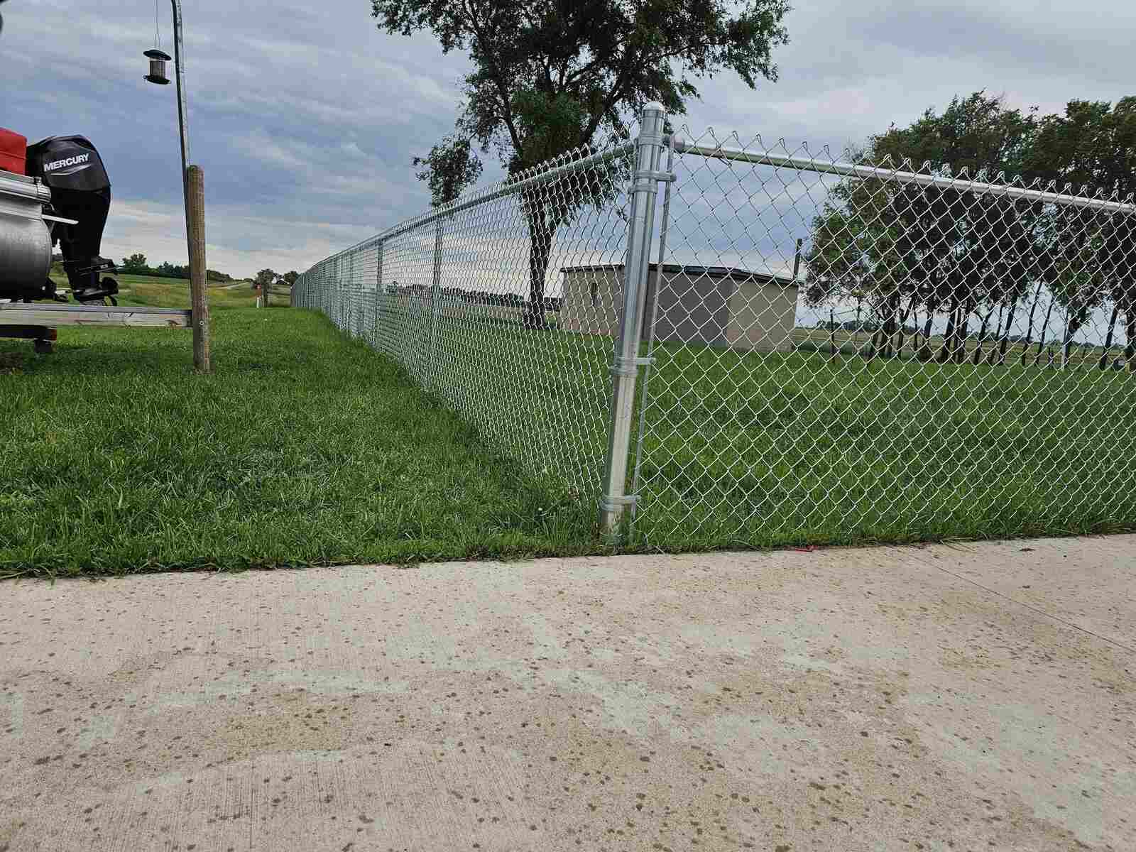 Galvanized chain link fence along a driveway