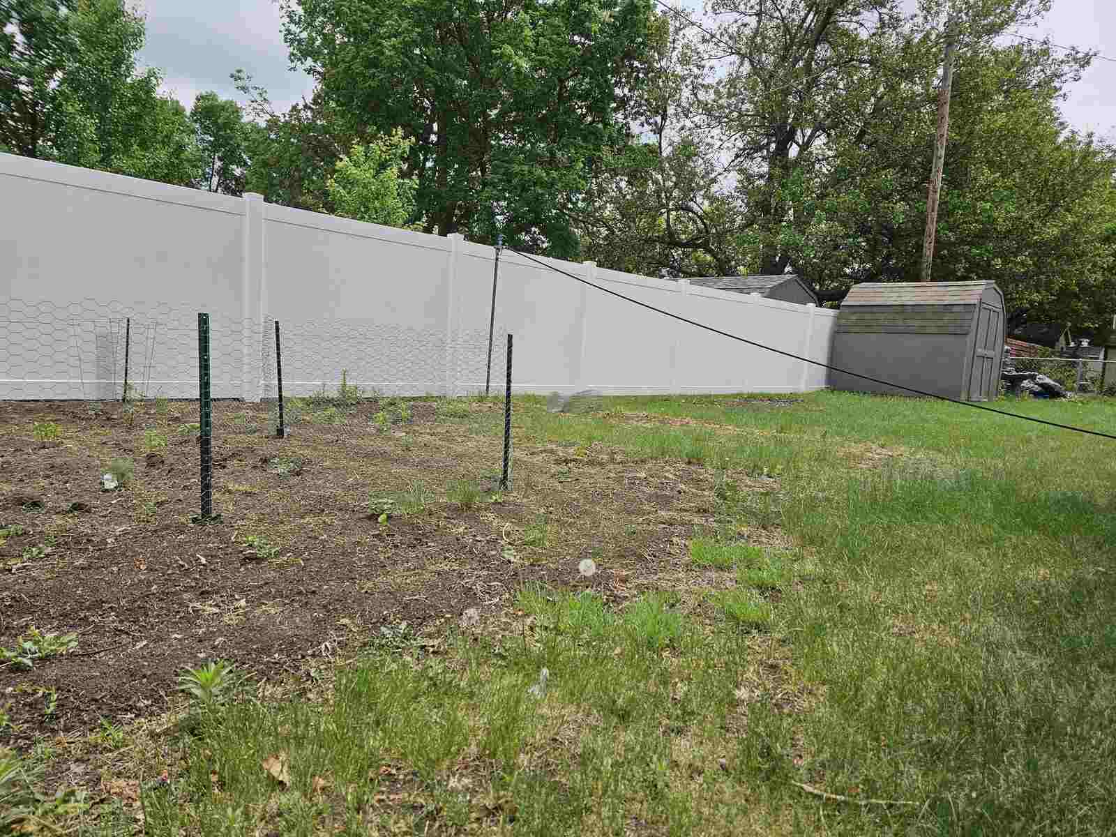 Vinyl privacy fence at a rural yard edge