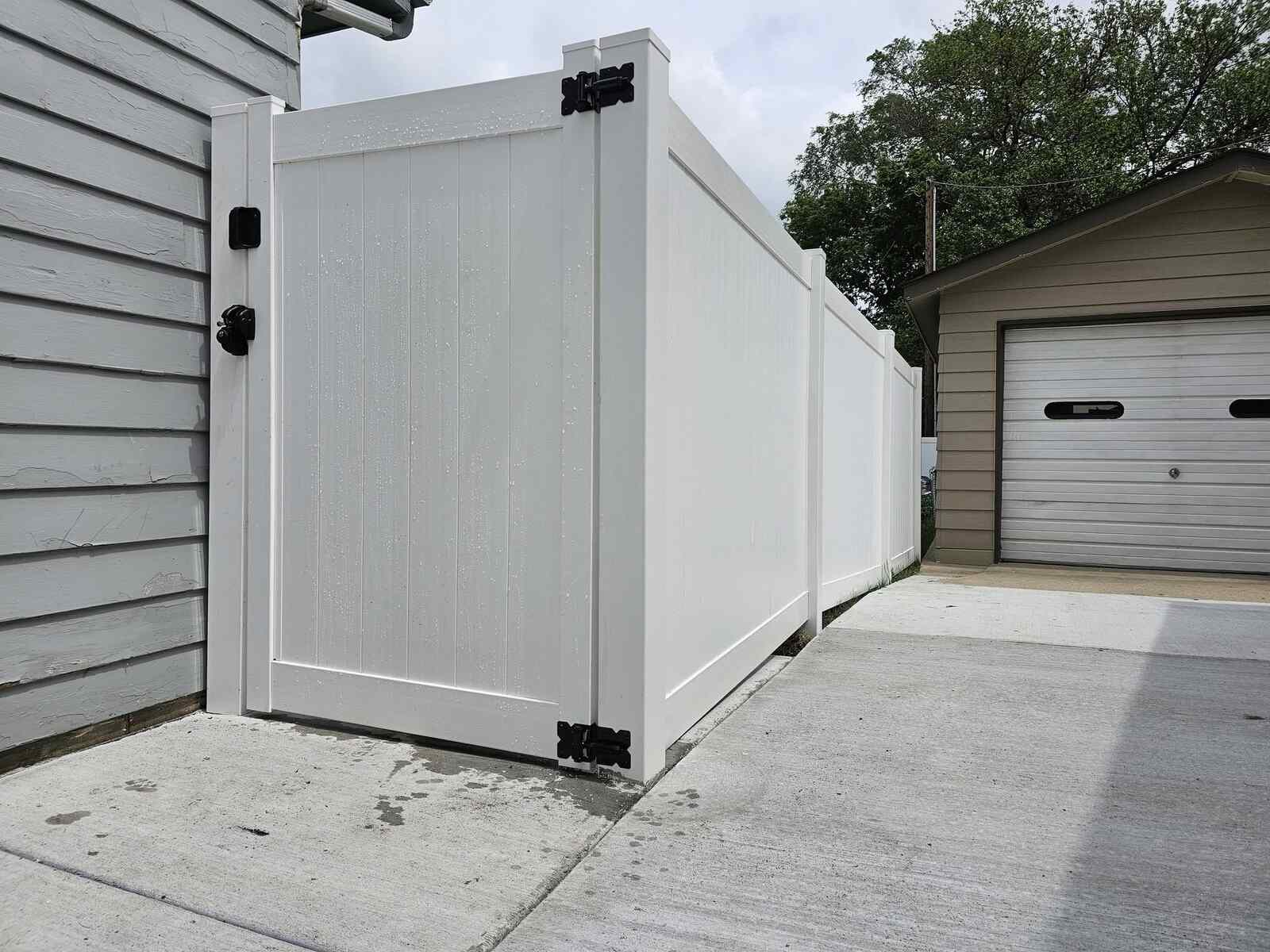 White vinyl privacy gate near a garage