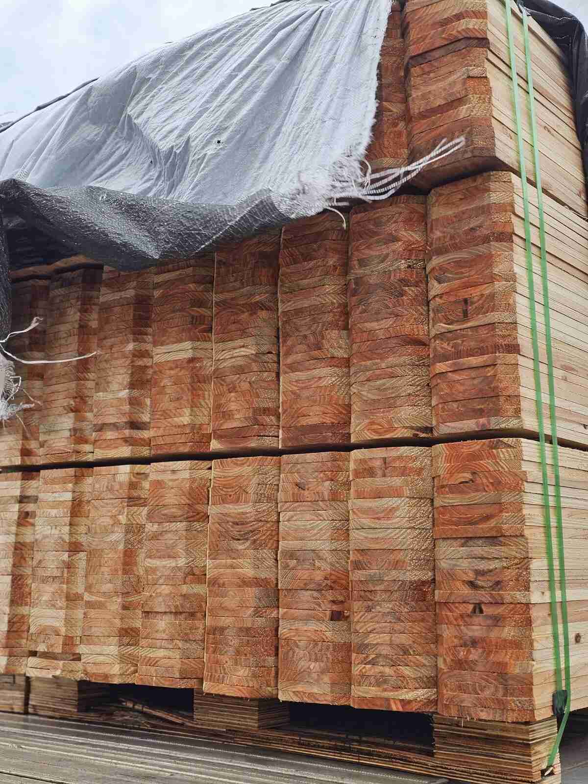 Bundled fence materials stacked on pallets in the yard