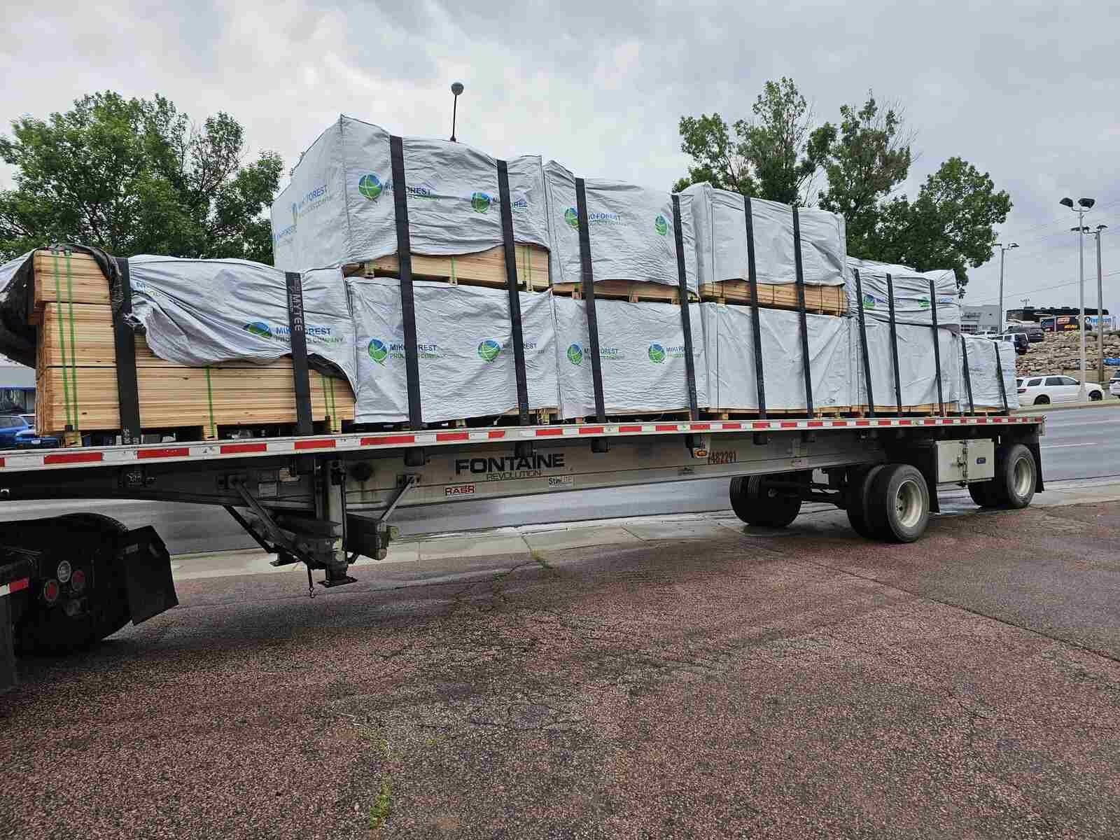 Flatbed trailer loaded with wrapped fence materials