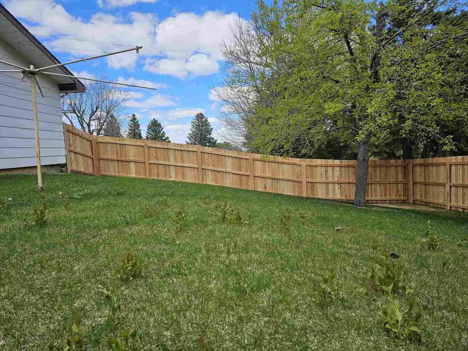 Cedar privacy fence run along the trees