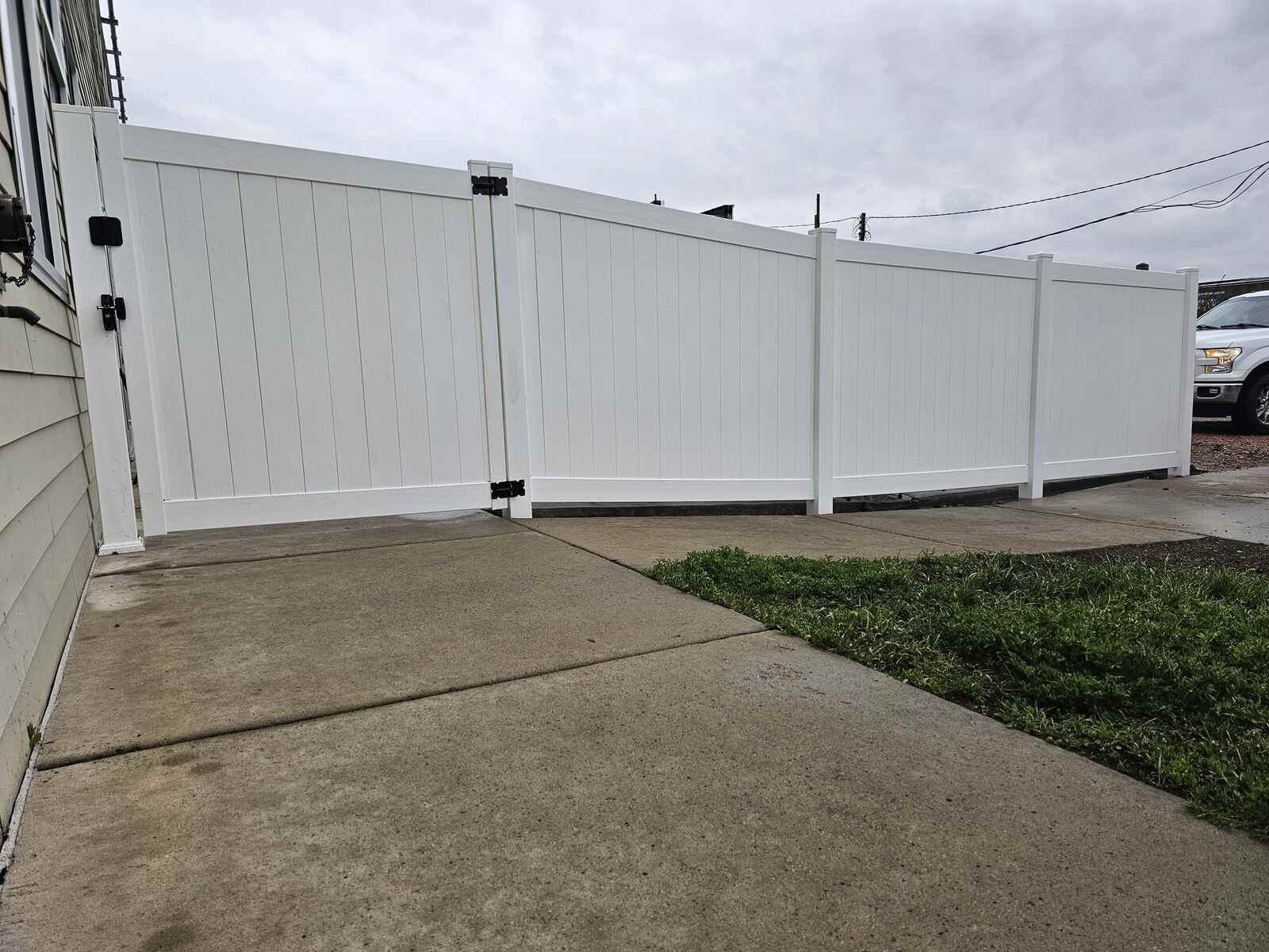 White vinyl privacy fence and gate along the driveway