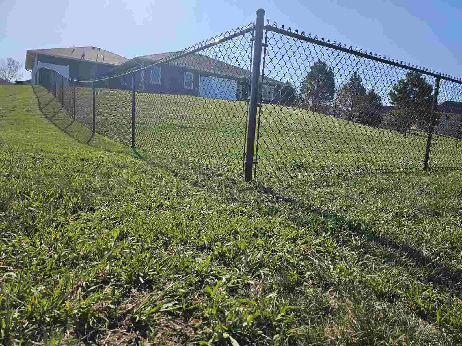 Black chain link fence at the edge of a rural neighborhood