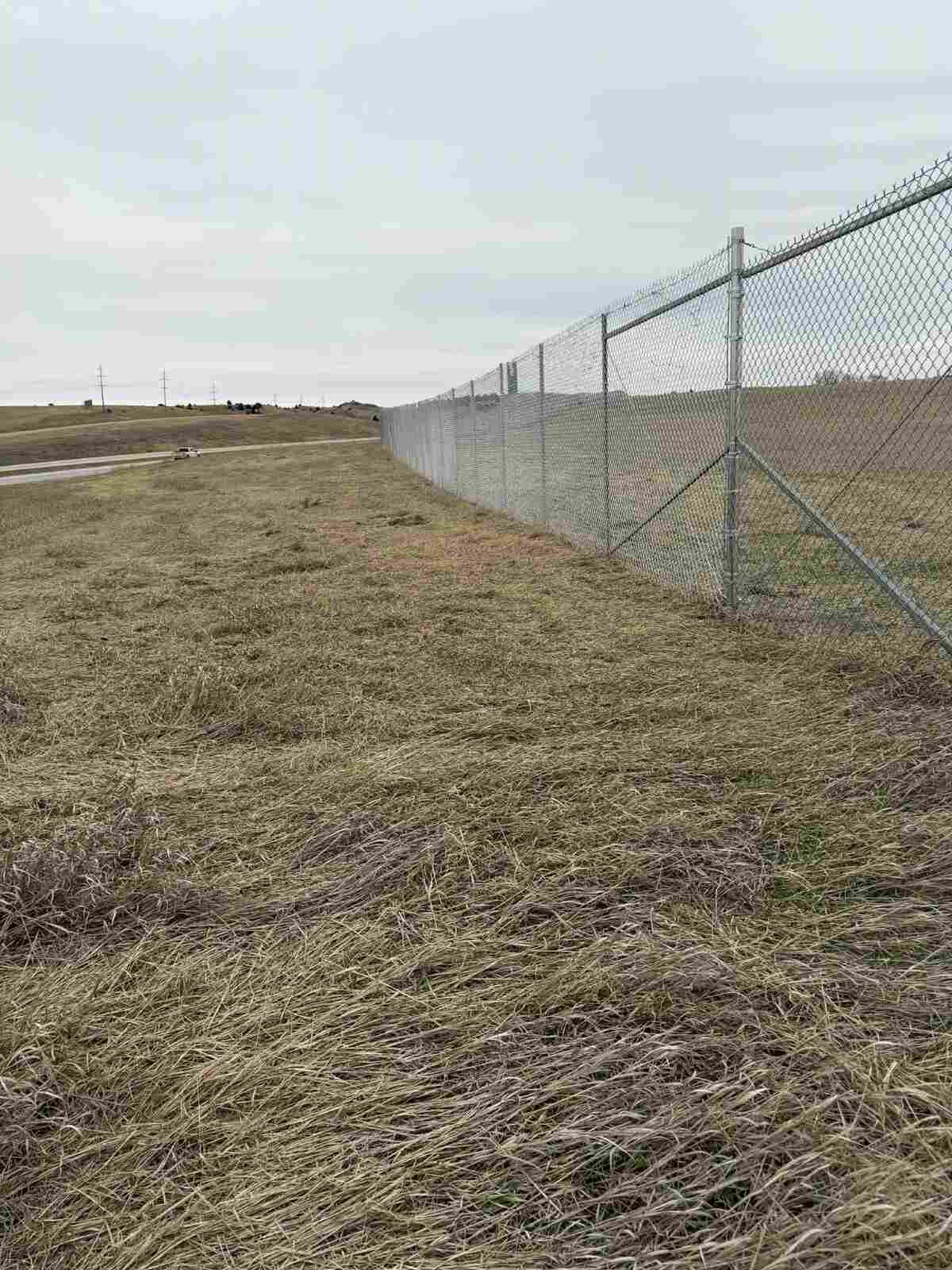 Galvanized chain link security line running into the distance